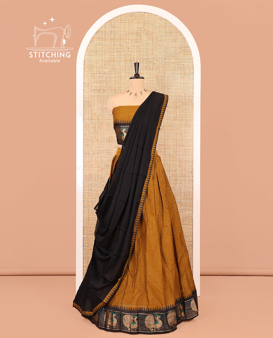 Mustard-Black Chettinad Cotton Half-Saree Set Featuring a Plain Skirt, Contrast Temple Peacock Motif Border, a Matching Blouse, and a Contrast Temple Dhavani