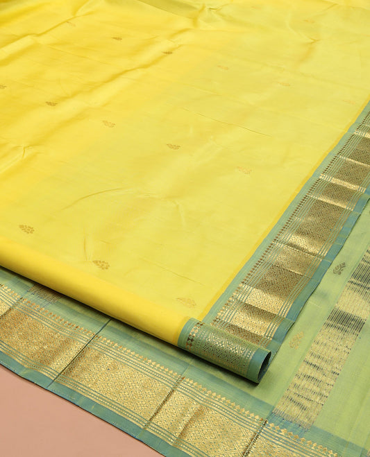 Yellow Kanchipuram Silk Saree, Gracefully Embellished with Zari Buttas on Its Body, Complemented by a Contrast One-Sided Border of Panner Sombu, Banaras, Muthu, and Jaal Designs, Pallu of Zari Designs, and Comes Without a Blouse