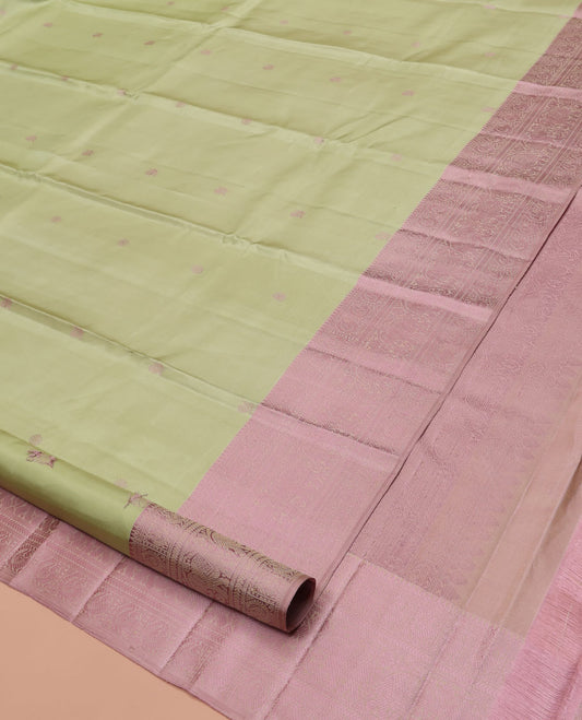 Pale Green Kanchipuram Designer Silk Saree, Subtly Sparkled With Buttas All Over Its Body Complemented by Contrast Traditional Designs Threaded Border, Subtly Woven Pallu, and Paired with a Contrast Blouse