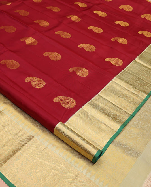 Maroon Vasundhara Silk Saree, Adorned with Arumbu Manga Buttas All Over Its Body, Complemented by Contrast Border of Thilakam Mokku, Mayil and Mayil Kann Designs, Grand Pallu and Paired with a Contrast Blouse