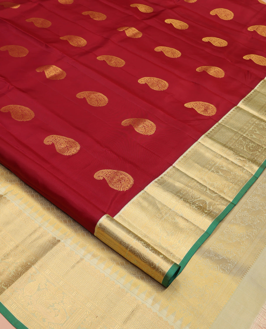 Maroon Vasundhara Silk Saree, Adorned with Arumbu Manga Buttas All Over Its Body, Complemented by Contrast Border of Thilakam Mokku, Mayil and Mayil Kann Designs, Grand Pallu and Paired with a Contrast Blouse