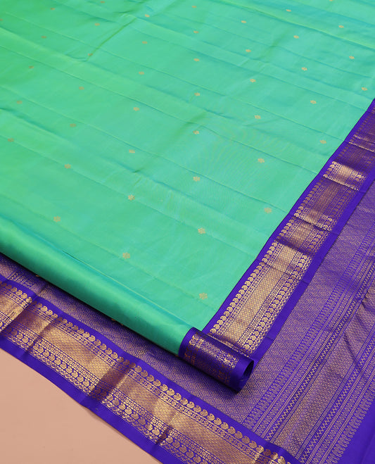 Greenish Turquoise Vasundhara Silk Saree, Showcasing Zari Buttas All Over Its Body, Complemented by a Contrast Border of Manga, Diamond, and Mayil Kann Designs, Grand Jaal Pallu, and Paired with a Contrast Blouse