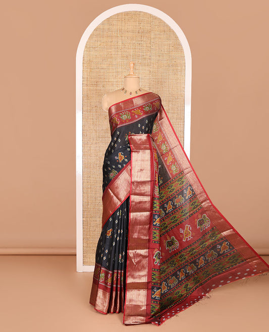 Black patola elephant motifs printed Dola silk saree, contrast zari border, and pallu of animal patola motifs print, and a contrast butta printed blouse