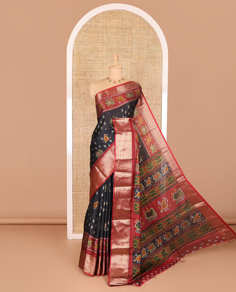 Black patola elephant motifs printed Dola silk saree, contrast zari border, and pallu of animal patola motifs print, and a contrast butta printed blouse