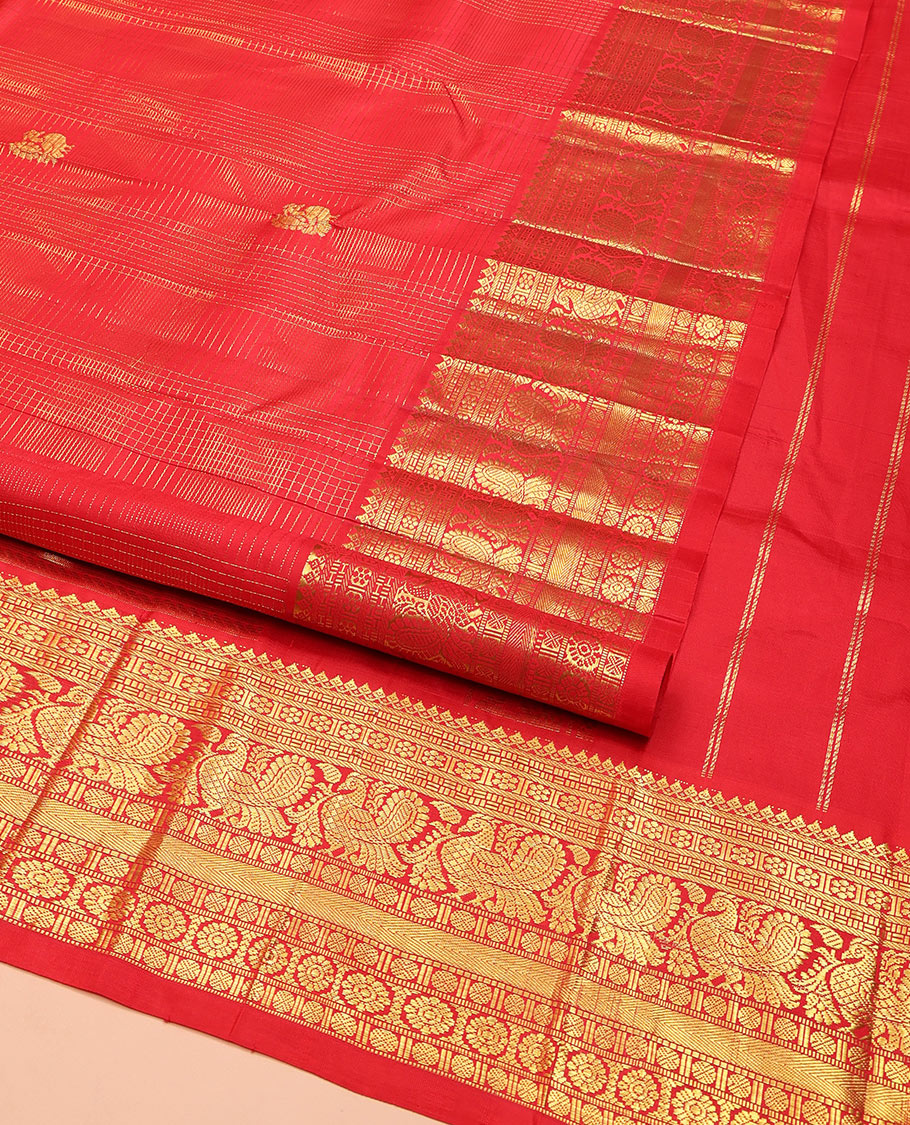 Red Kanchipuram Silk Saree, Gleamed Up with Mayil Butta Enclosed Checks, Highlighted by One-Sided Border of Thilakam Mokku, Kamalam, Mayil, Chakram, and Rudraksham Designs, Pallu of Chakram and Mayil Designs, and Comes Without a Blouse