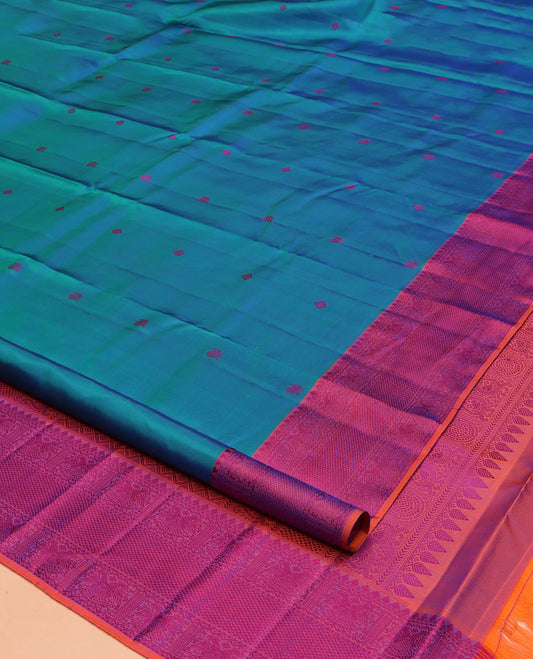 Blue Kanchipuram Silk Saree, Accentuated with Mayil-Chakram Buttas All Over Its Body, Complemented by a Contrast Border of Thilakam Mokku, Iruthalai Pakshi, and Kuyil Kann Designs, and Pallu of Jaal Designs, and Paired with a Contrast Blouse