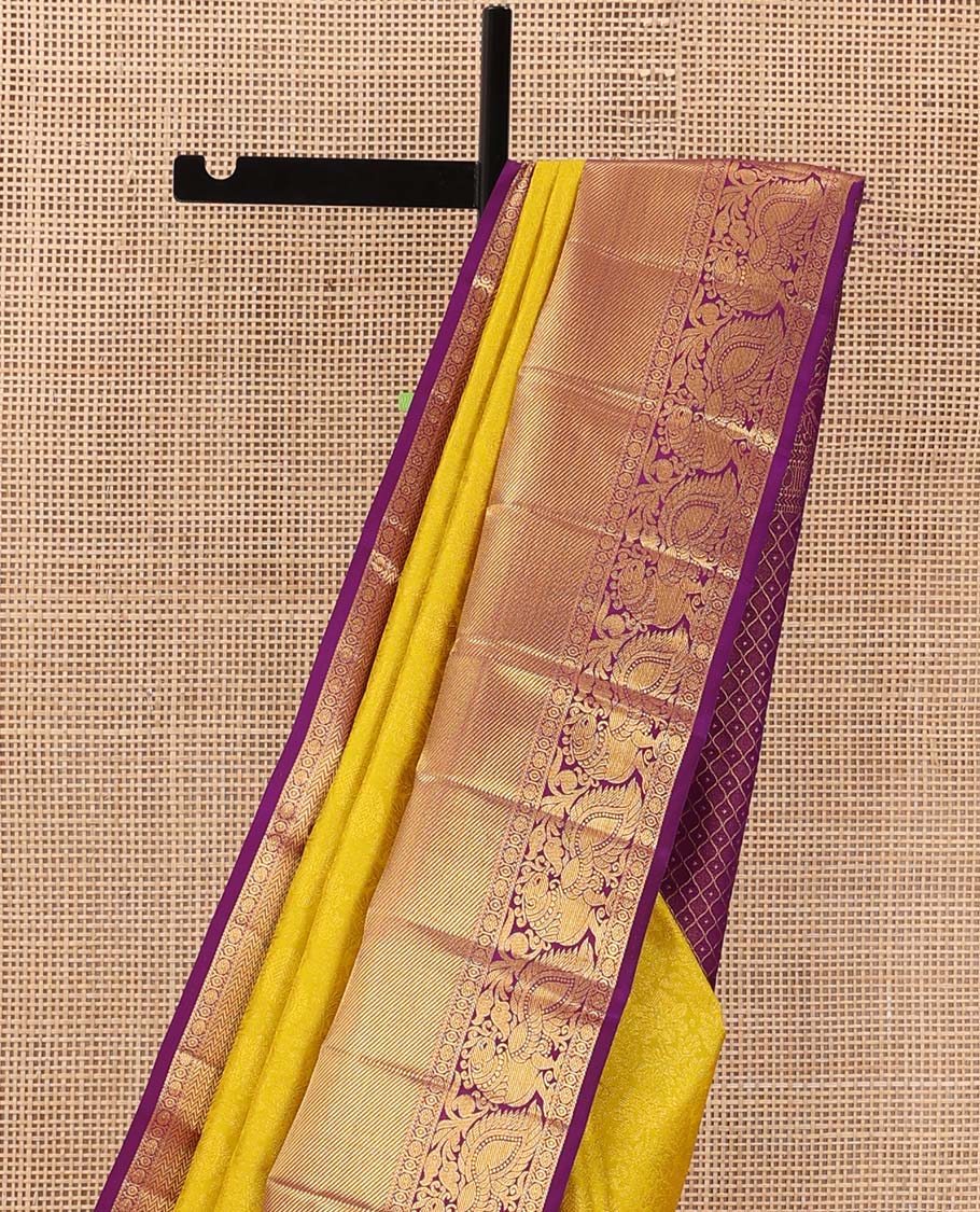 Yellow jacquard wedding silk saree, contrast border of thilakam, rudraksham, and mayil designs, and ogee design pallu
