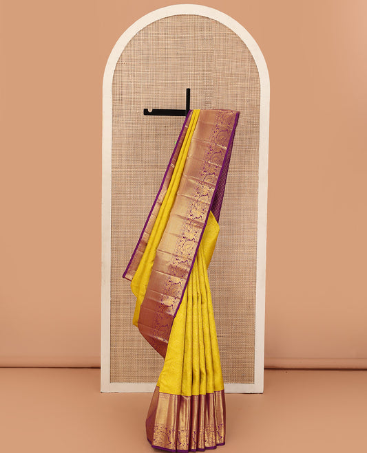 Yellow jacquard wedding silk saree, contrast border of thilakam, rudraksham, and mayil designs, and ogee design pallu