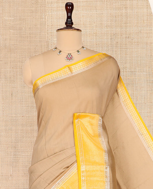 Pale Brown Plain Assam Silk Saree, Complemented by a Contrast Traditional Zari Design Border of Rudraksha Motifs, a Gleaming Pallu of Zari Stripes, and Paired with a Contrast Blouse