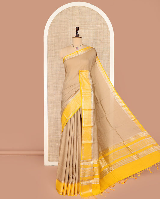Pale Brown Plain Assam Silk Saree, Complemented by a Contrast Traditional Zari Design Border of Rudraksha Motifs, a Gleaming Pallu of Zari Stripes, and Paired with a Contrast Blouse