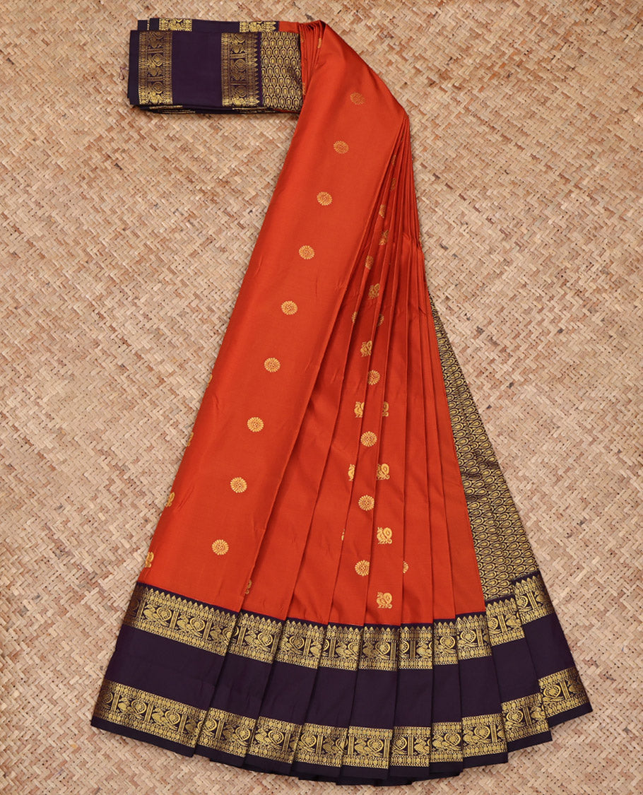 Rust Budget Silk Saree, Accentuated with Peacock and Chakram Buttas All Over Its Body, Complemented by a Contrast Traditional Zari Rettai Pettu Border of Peacock Designs, Pallu Steeped Thilakam Designs, and Paired with a Contrast Blouse
