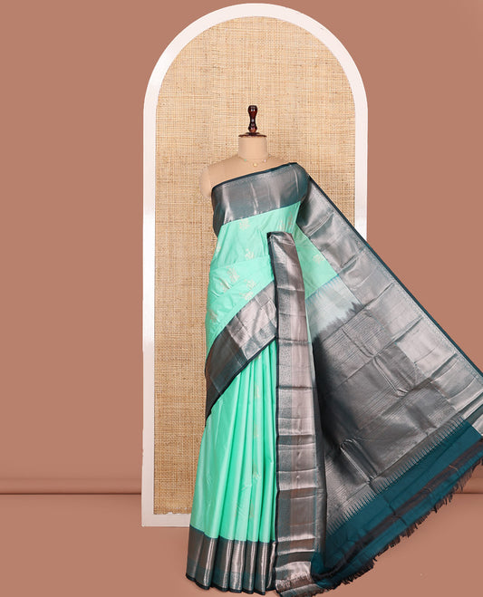 Turquoise Budget Silk Saree, Gleamed Up with Floral Zari Buttas All Over Its Body, Complemented by Contrast Border of Traditional Designs Woven in Zari, Beautifully Bedecked Pallu, and Paired with a Contrast Blouse