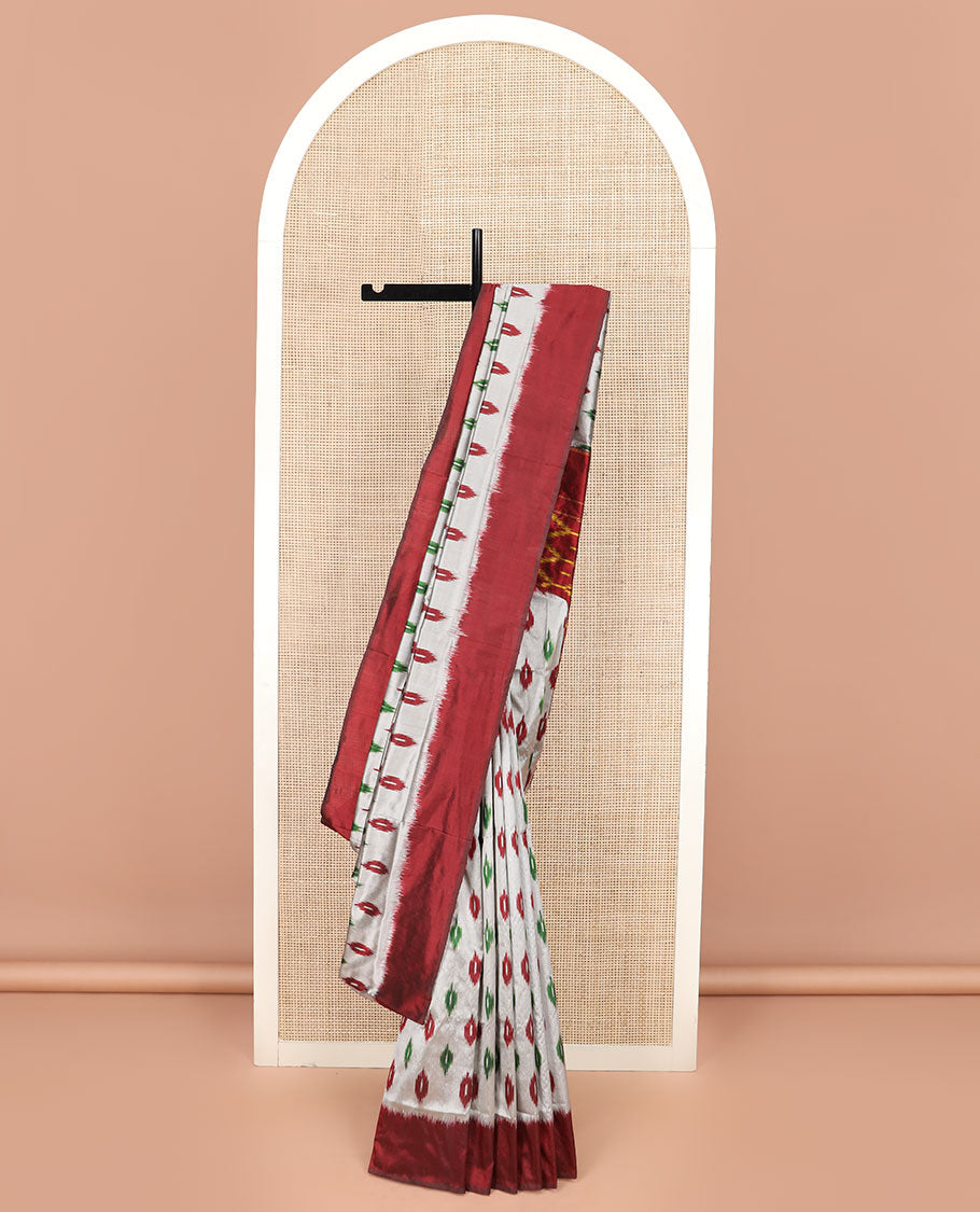 Grey Ikkat Silk Saree Adorned with Ikkat Buttas, Featuring a Contrast Plain Border, Complemented by a Pallu Ikkat Woven in an Ogee Pattern