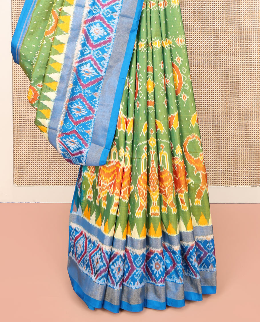 Green Ikkat Silk Saree, Enriched with Elephant Motifs Ikkat Weave All Over Its Body, Complemented by a Contrast Temple Border of Diamond Designs, Pallu of Ikkat Designs, and Paired with a Contrast Blouse
