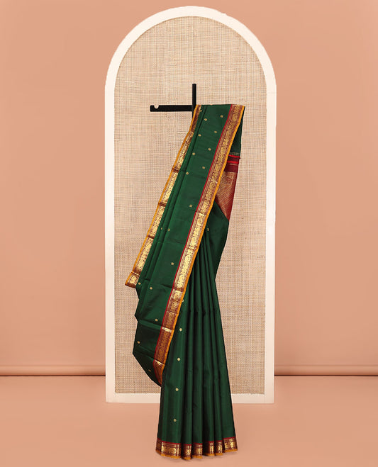 Green Kanchipuram Silk Saree, Elevated with Zari Buttas All Over Its Body, Complemented by Contrast  Border of Rekku, Muthu, Banaras, Yaanai, and Mayil Designs, Pallu Steeped with Geometric Designs, and Paired with a Contrast Blouse