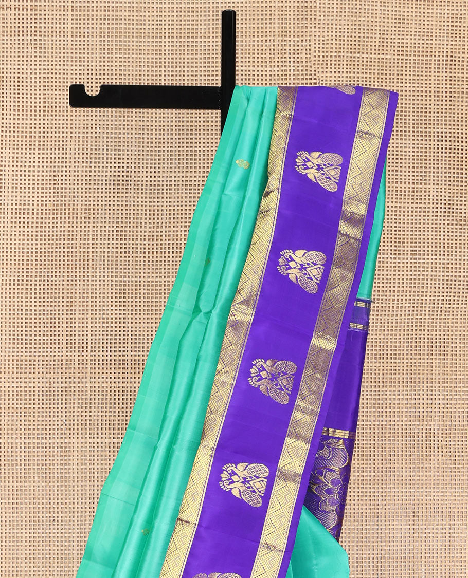 Turquoise Kanchipuram Silk Saree, Beautified with Zari Buttas on Its Body, Complemented by Contrast One-Sided Korvai Border of Diamond Designs, Pallu Steeped with Paisley and Floral Designs, and Comes Without a Blouse