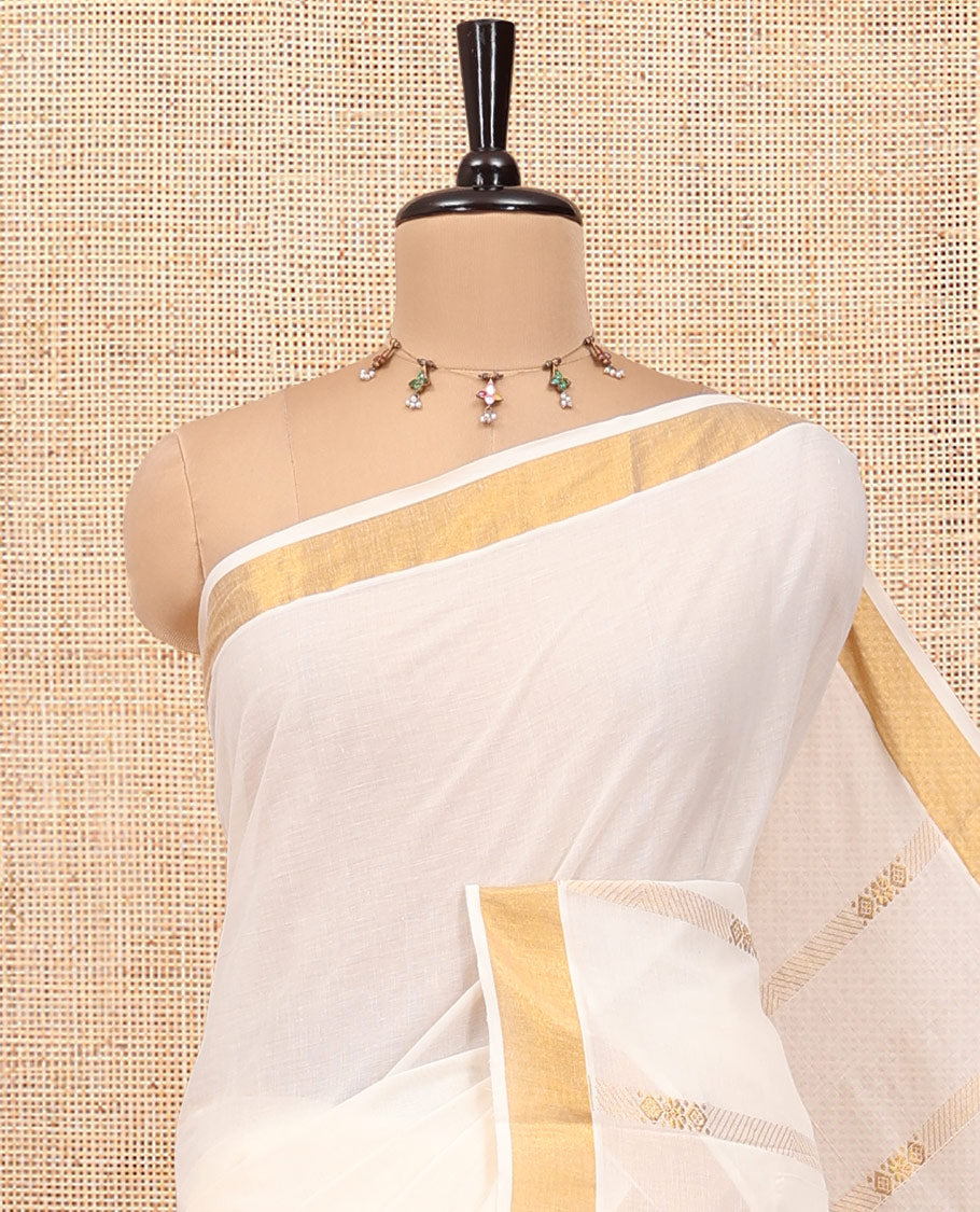 Cream Kerala Cotton Saree, Woven with Zari Stripes All Over Its Body, a Subtle Bavanji Border, Pallu Depicts Intricate Designs, and Paired with a Matching Blouse