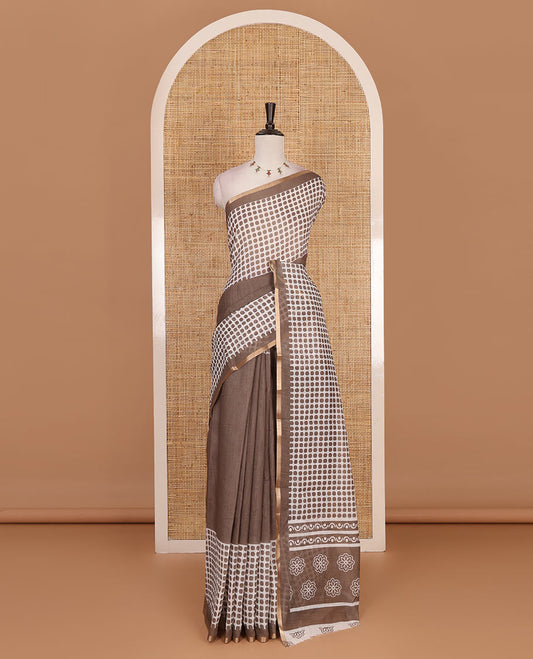 Brown plain and polka dots printed linen cotton saree with piping zari border, floral-geometric print pallu, and contrast flower buttas printed  blouse
