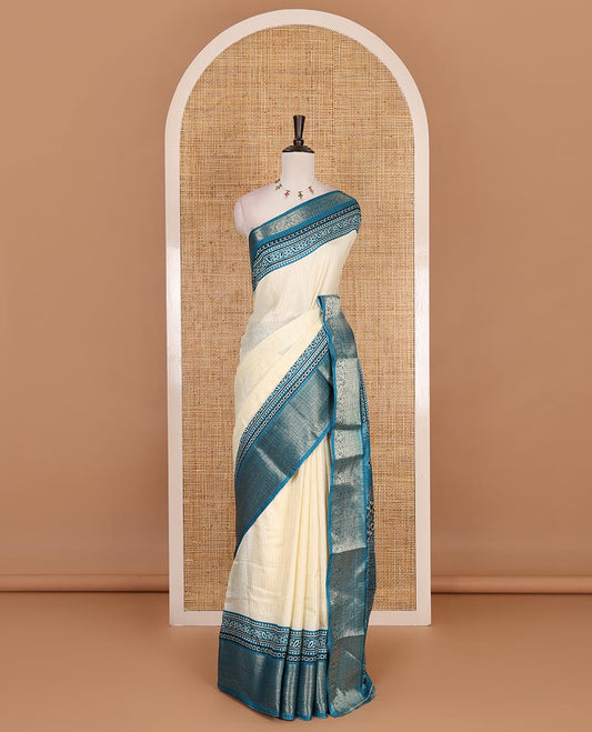 Cream-rama blue zari striped dola silk saree, contrast traditional zari border of leaf creeper, Ajrakh printed pallu, and Ajrakh printed blouse