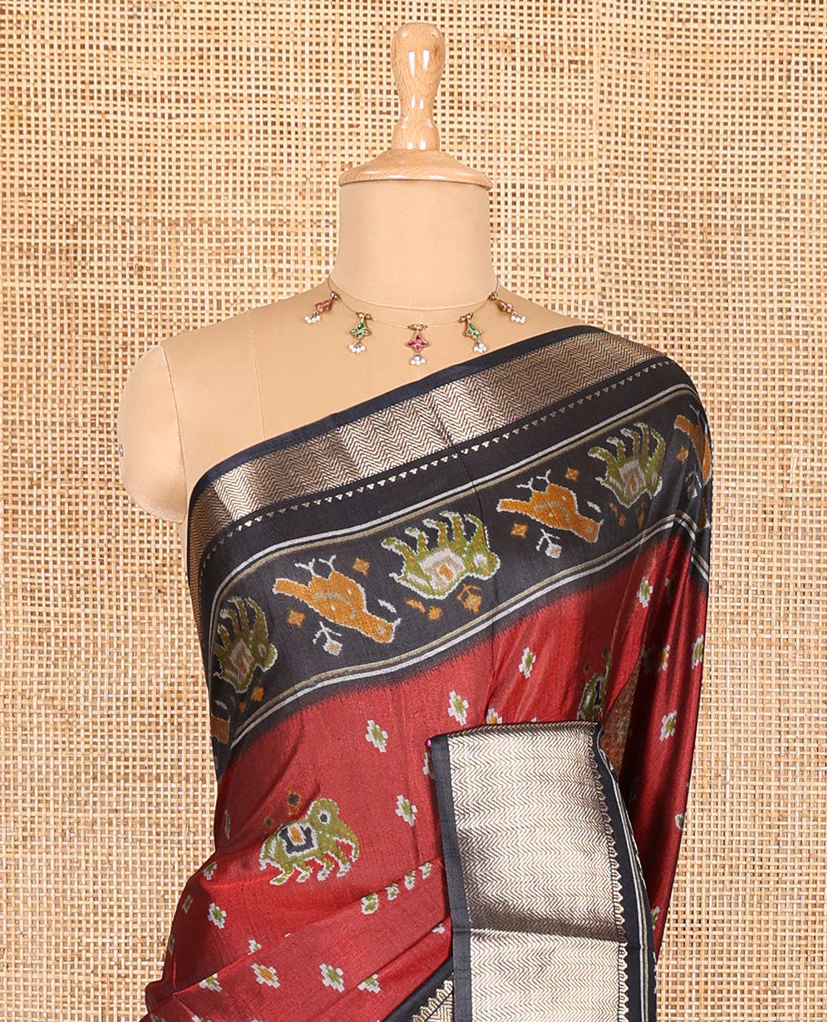 Maroon patola elephant motifs printed Dola silk saree, contrast zari border, and pallu of animal patola motifs print, and a contrast butta printed blouse
