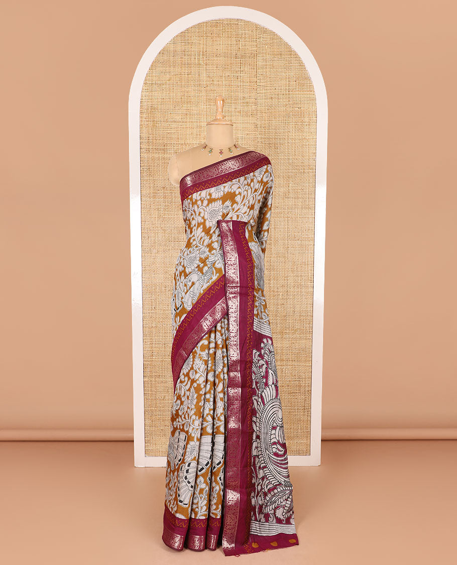 Mustard kalamkari floral vine and peacock printed muslin cotton saree, contrast zari border, kalamkari peacock printed pallu, and a contrast coin buttas printed blouse