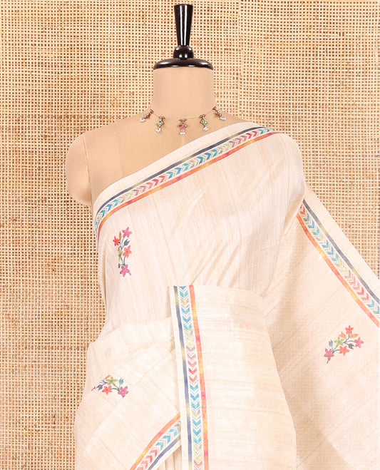 Chikku Semi-Tussar Silk Saree, Embellished with Floral Motifs Printed on Its Body, a Subtle Chevron Striped Border, Pallu Accentuated by Colorful Floral Vine and Bird Print, and Paired with a Matching Printed Blouse