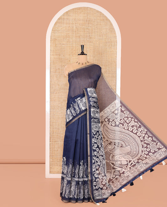 Navy Blue Chanderi Cotton Saree, Elevated with Kalamkari-Style Ancient Human Figurines Printed on Its Body, Subtle Zari Piping Border, Pallu Depicting Kalamkari Peacocks, and Paired with a Matching Blouse