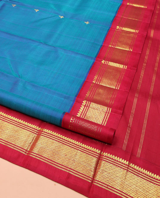 Blue Kanchipuram Silk Saree, Embellished with Zari Buttas on Its Body, Complemented by a Contrast One-Sided Korvai Border of Thilakam Mokku, Banaras, and Lavangam Designs, Pallu of Zari Designs, and Comes Without a Blouse