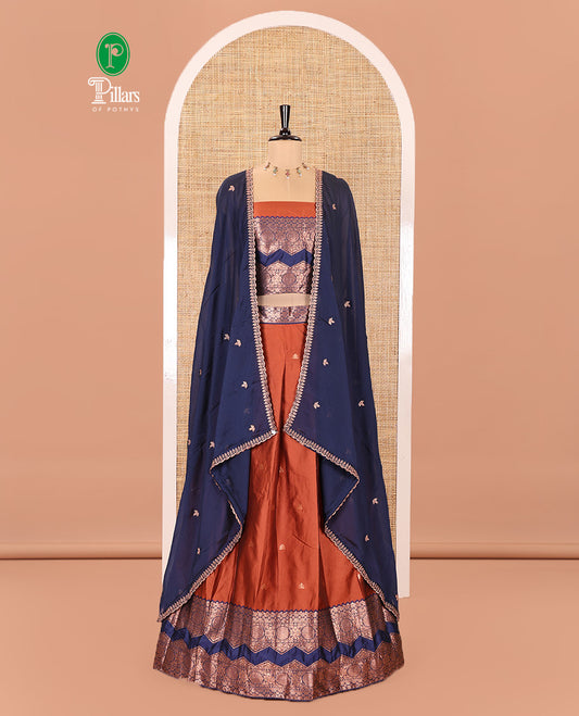 Orange and Navy Blue Semi-Banarasi Half-Saree Elevated with Zari Buttas on Its Skirt, Complemented by Contrast Traditional Zari Border of Chakram Designs, Paired with a Matching Blouse, and a Satin Georgette Embroidered Scallop Dhavani