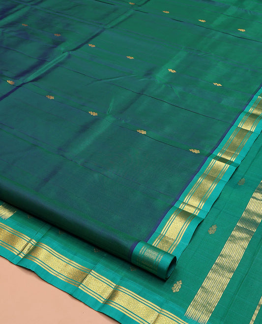 Green Kanchipuram Silk Saree, Gleamed Up with Zari Buttas on Its Body, Complemented by a Contrast One-Sided Border of Banaras, and Jaal Designs, Pallu of Zari Designs, and Comes Without a Blouse