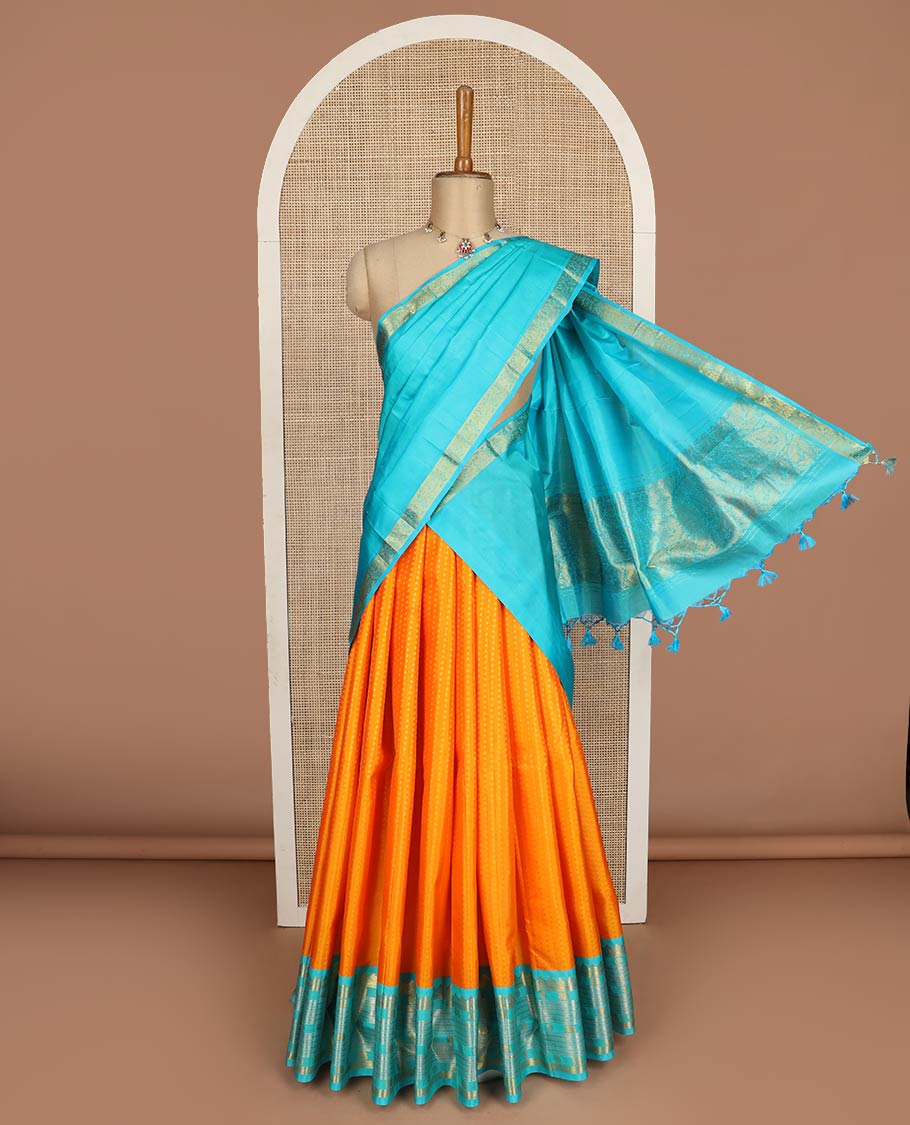 Orange pure-silk half-saree, buttas with a contrast mayil chakram bordered skirt, contrast blouse, and a leaf jaal dhavani