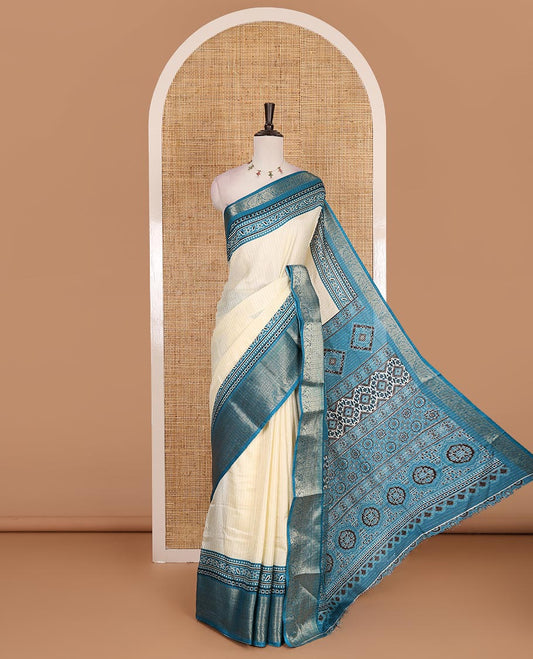 Cream-rama blue zari striped dola silk saree, contrast traditional zari border of leaf creeper, Ajrakh printed pallu, and Ajrakh printed blouse
