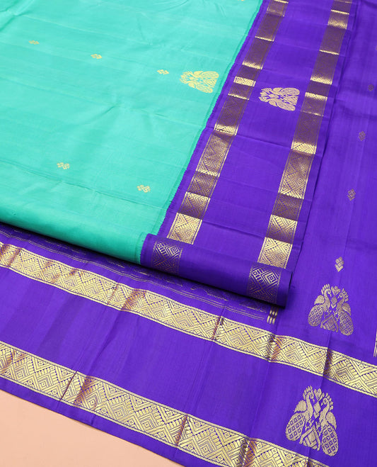 Turquoise Kanchipuram Silk Saree, Beautified with Zari Buttas on Its Body, Complemented by Contrast One-Sided Korvai Border of Diamond Designs, Pallu Steeped with Paisley and Floral Designs, and Comes Without a Blouse