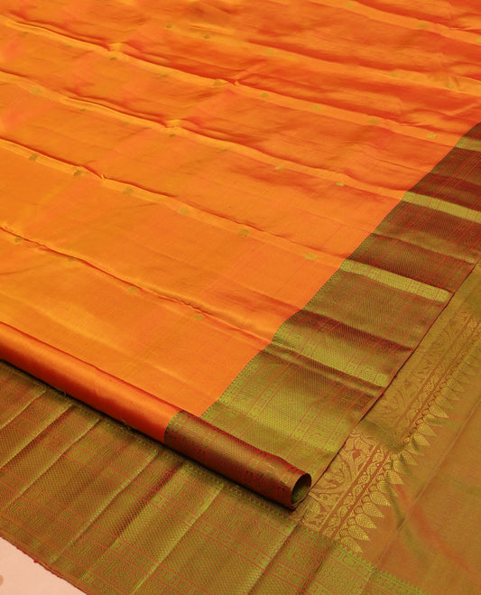 Orange Kanchipuram Silk Saree, Subtly Sparkled with Mayil-Chakram Buttas All Over Its Body, Complemented by a Contrast Border of Rekku, Kamalam, Poun, Chakram, Kuyil Kann, and Then Kuli Kann Designs, Jaal Design Pallu, and Paired with a Contrast Blouse