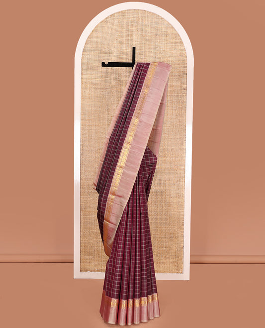 Maroon checked Kanchipuram silk saree, contrast kaal eragina border of thilakam mokku, muthu, and mayil designs, and zari striped pallu