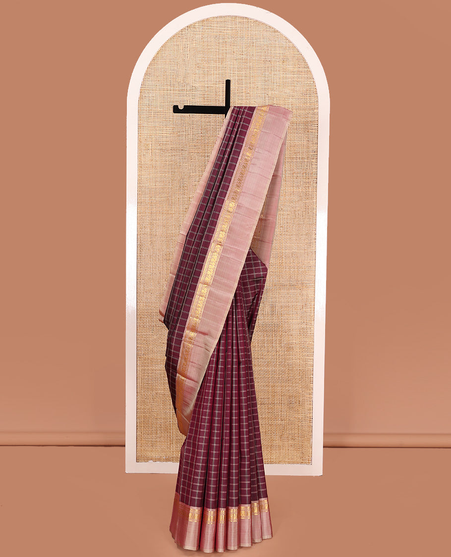 Maroon checked Kanchipuram silk saree, contrast kaal eragina border of thilakam mokku, muthu, and mayil designs, and zari striped pallu