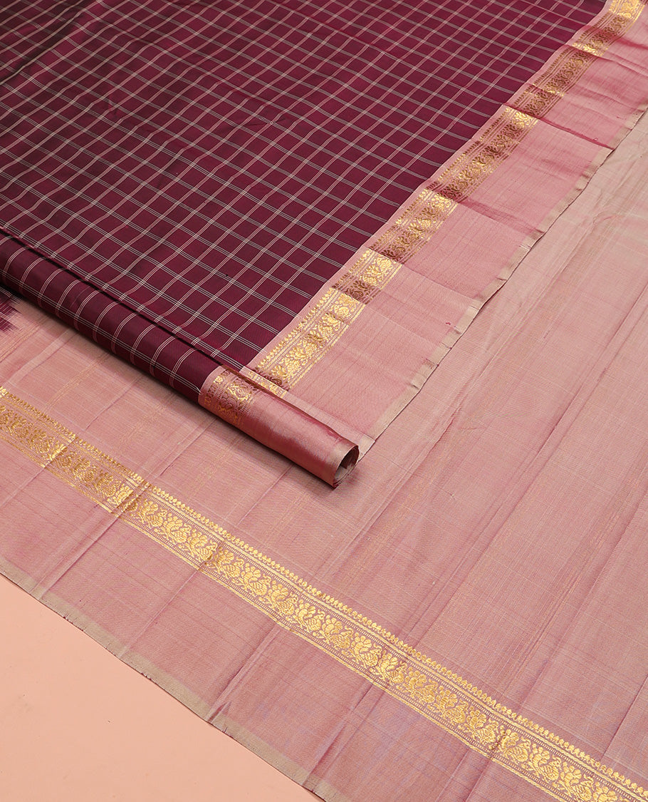 Maroon checked Kanchipuram silk saree, contrast kaal eragina border of thilakam mokku, muthu, and mayil designs, and zari striped pallu