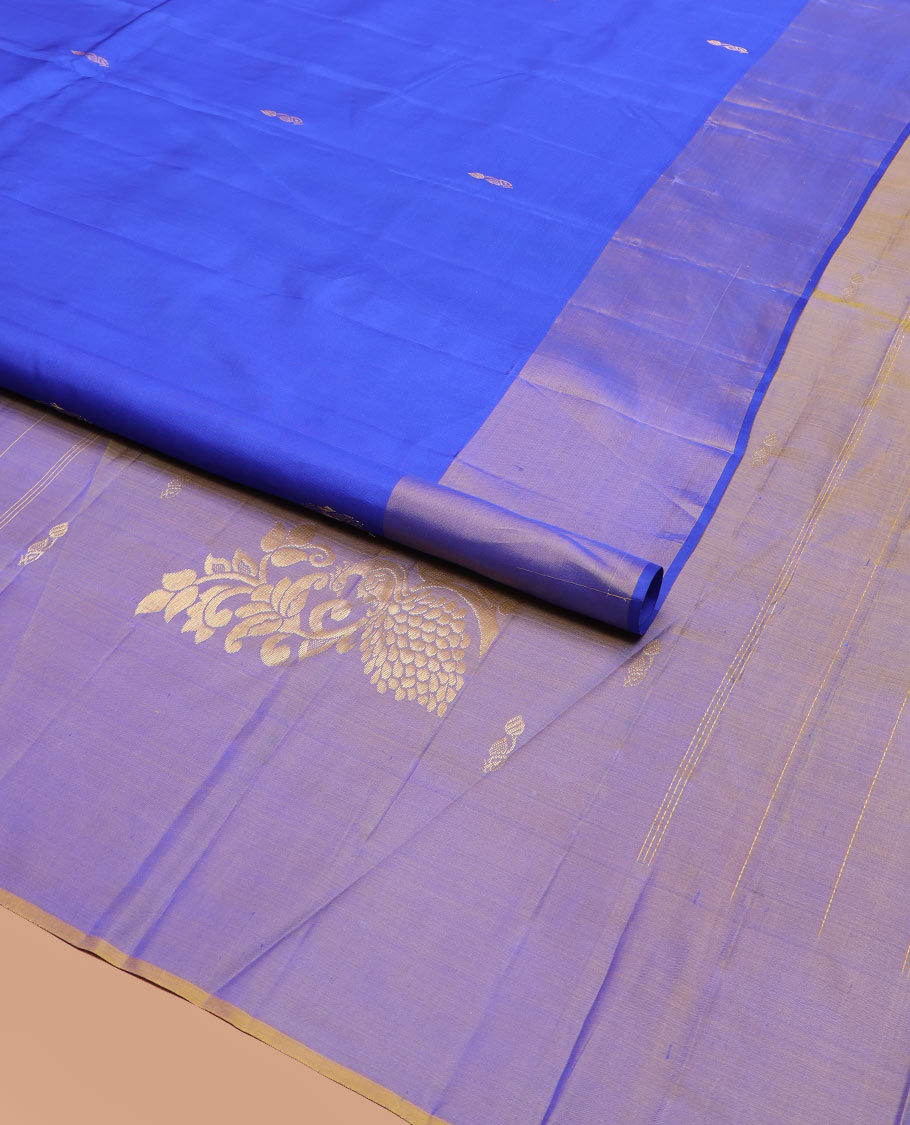 Blue Kanchipuram Silk Saree Featuring All-Over Zari Buttas, Highlighted by a Contrast Border with Manga Zari Buttas, and a Pallu Adorned with Mayil Motifs, Paired with a Subtle Contrast Plain Blouse