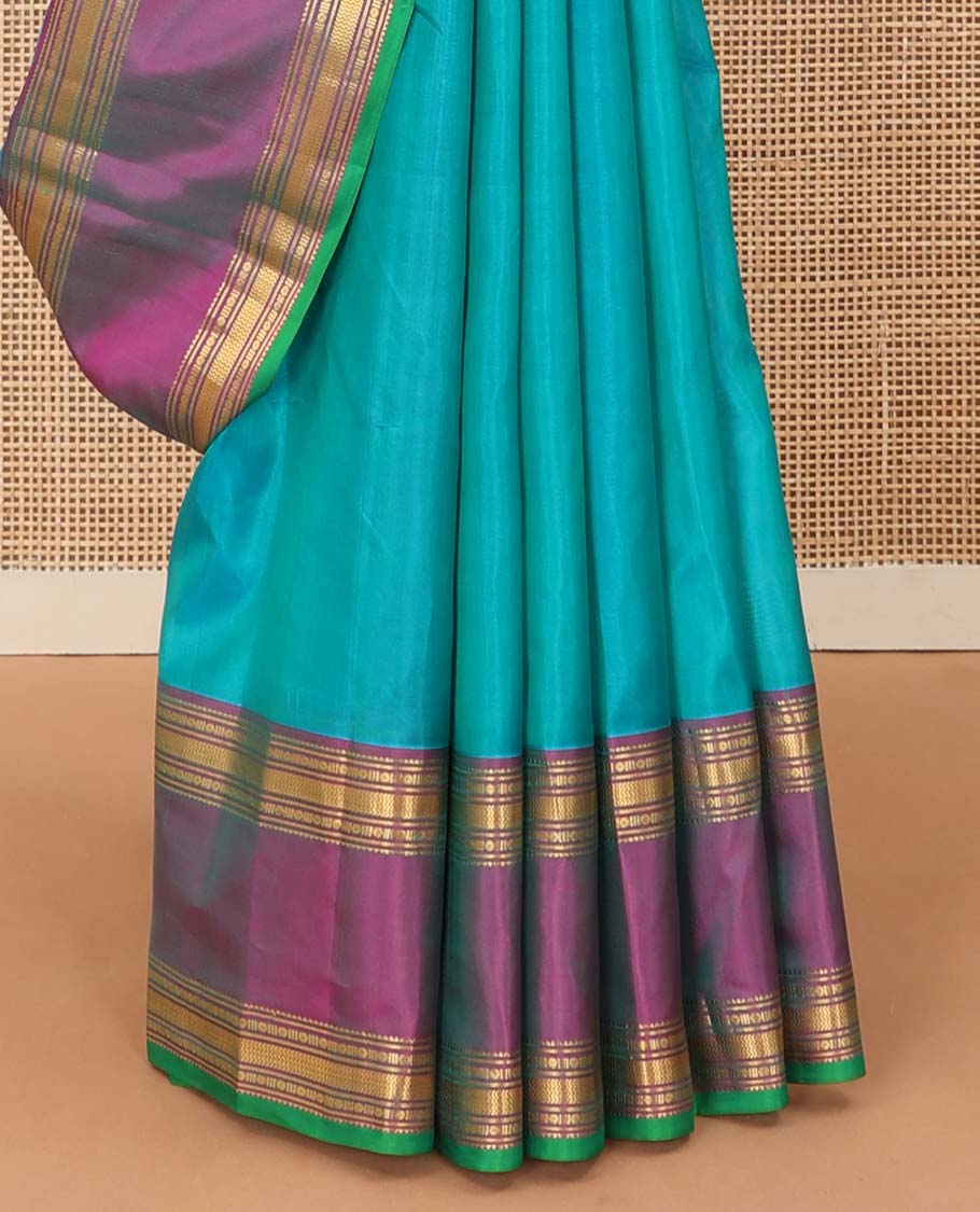 Blue plain Kanchipuram silk saree, contrast rettai pettu border of rekku, banaras, poun and vanki designs, and zari design pallu