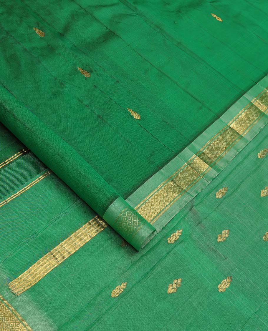 Green Kanchipuram Silk Saree, Beautified with Zari Buttas All Over Its Body, Complemented by Contrast One-Sided Border of Rekku, Banaras, and Mayil Kann Designs, Pallu of Zari Designs, and Comes Without a Blouse