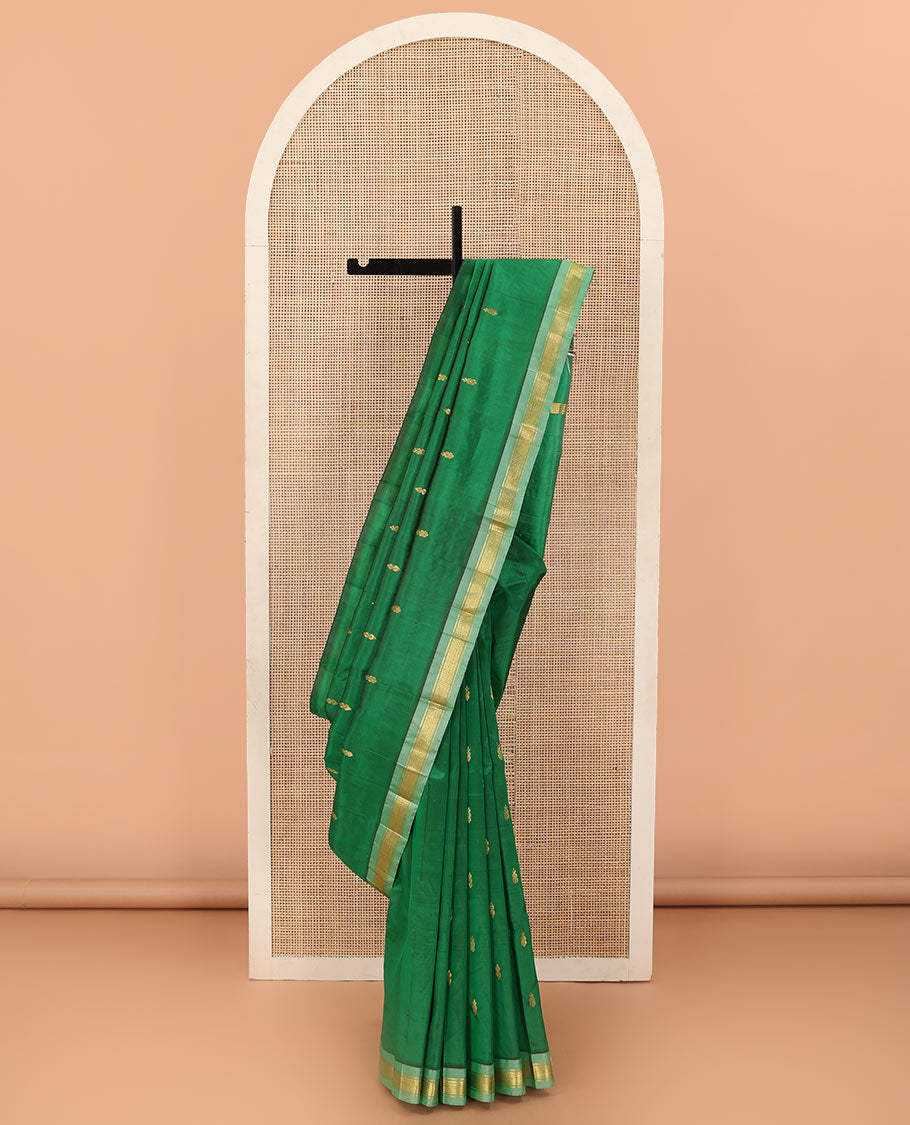Green Kanchipuram Silk Saree, Beautified with Zari Buttas All Over Its Body, Complemented by Contrast One-Sided Border of Rekku, Banaras, and Mayil Kann Designs, Pallu of Zari Designs, and Comes Without a Blouse