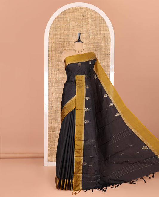 Black dobby and thilakam buttas semi-soft silk saree, contrast zari striped border, zari buttas pallu, and a matching blouse