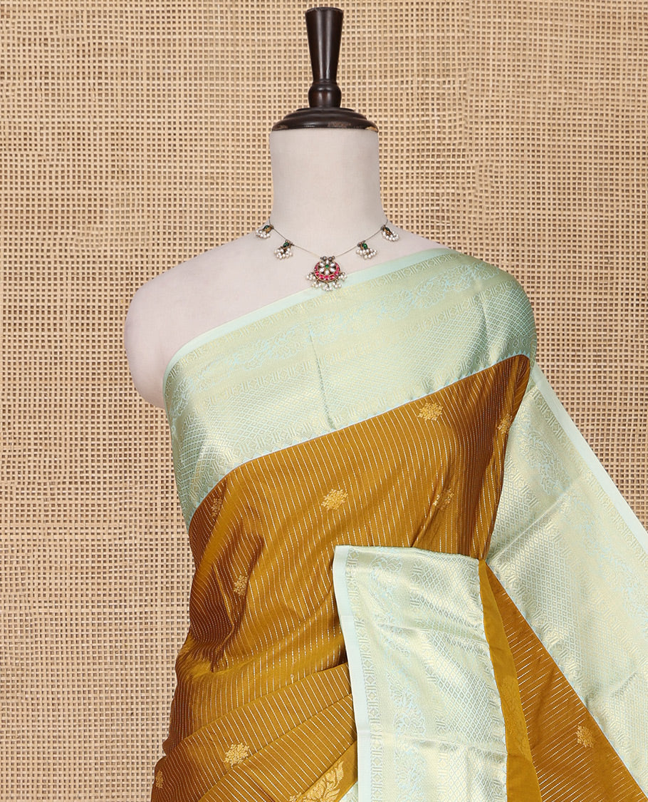 Mustard Budget Silk Saree, Detailed with Zari Buttas, Stripes and Paisleys on Its Body, Complemented by a Contrast Traditional Zari Design Border, Opulently Embellished Pallu, and Paired with a Contrast Blouse