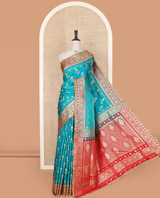 Blue floral buttas with stone work banarasi silk saree, contrast lace zari border of floral creeper designs, and pallu of Mughal-style intricate motifs