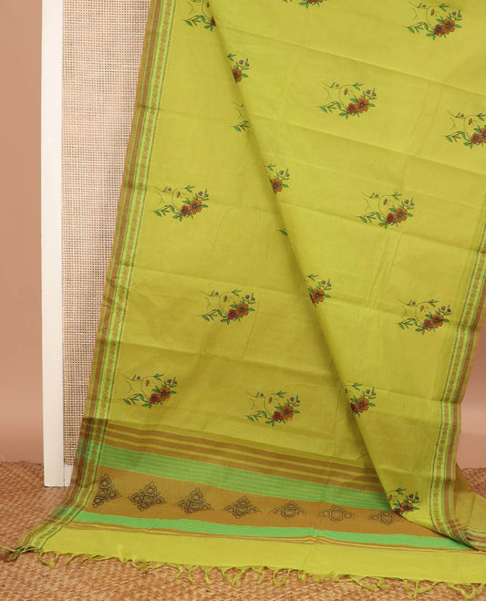Green girl with a floral head motifs printed chirala cotton saree, traditional border, and pallu of stripes and kolam motifs print