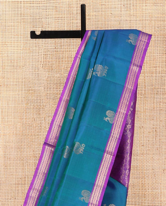 Blue Mayuri Soft Silk Saree, Decorated with Mayil Buttas All Over Its Body, Complemented by Contrast Border of Muthu, Banaras, and Chevron Designs, Pallu Elevated with Floral Creeper Designs, and Paired with Contrast Blouse