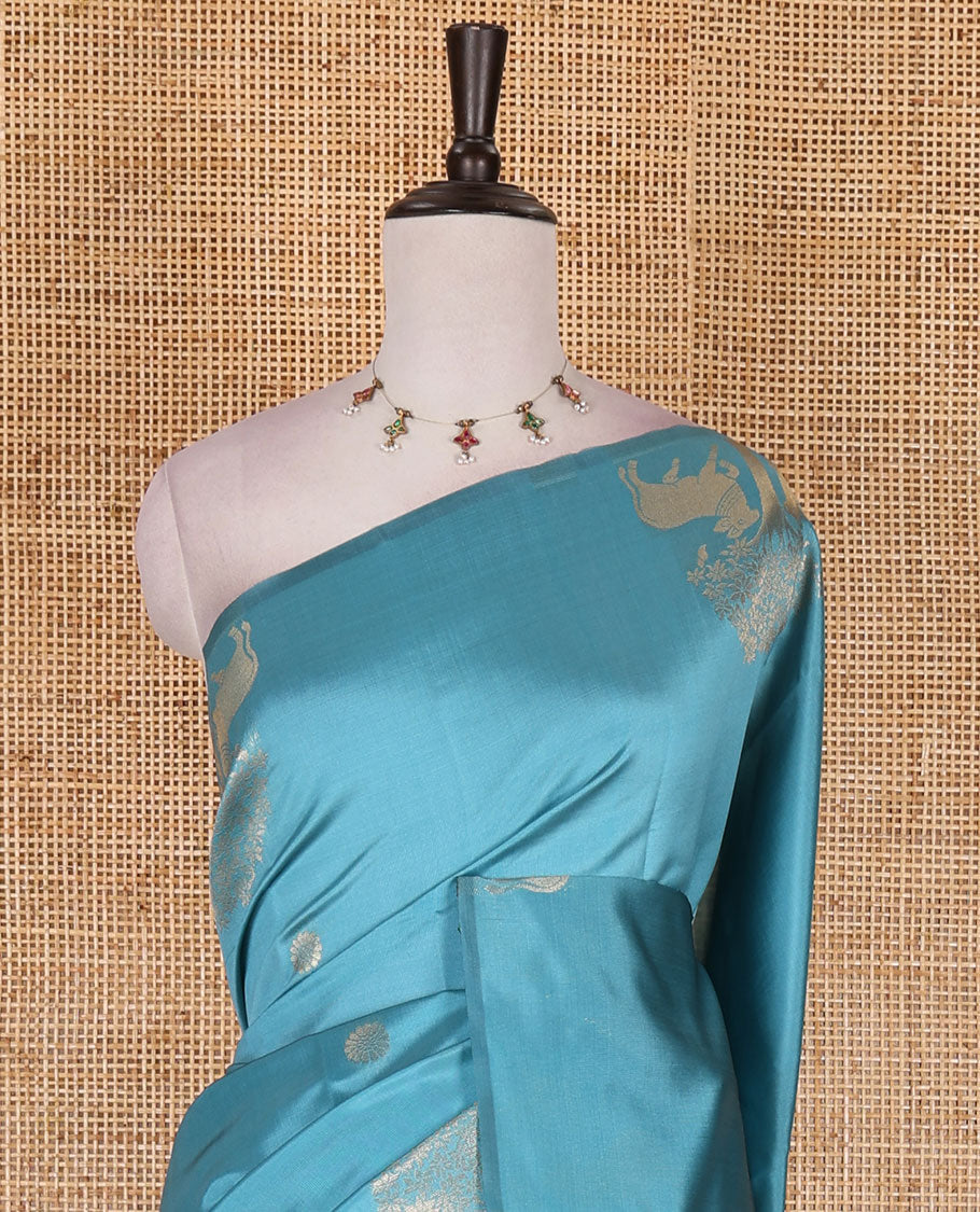 Borderless sky blue peacock, chakra, and pichwai cow buttas zari woven kanchi silk saree, peacock and chakra enclosed checked pallu, and matching blouse