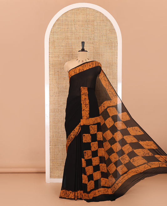 Black and mustard plain georgette saree, batik printed border, batik printed checked pallu, and a matching blouse