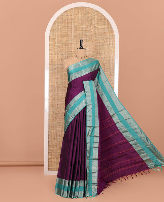 Purple Plain Semi-Soft Silk Saree, Complemented by a Contrast Zari Woven Border, Pallu Features Sparse Stripes, and Paired with a Matching Blouse