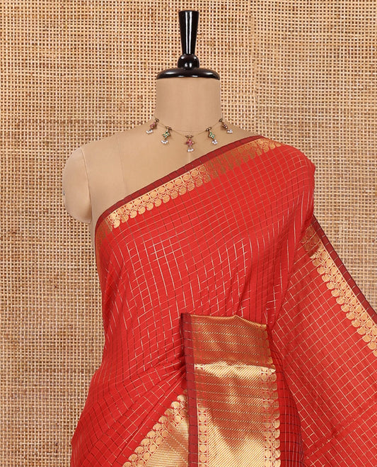 Red Semi-Katan Silk Saree, Embellished with Golden Zari Checks on Its Body, Highlighted by a Traditional Zari Border of Paisley and Rudraksham Designs, Gleaming Pallu, and Paired with a Matching Blouse
